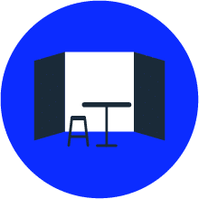 Icon of a blue circle with a black stool and table in front of a white wall and black panels.