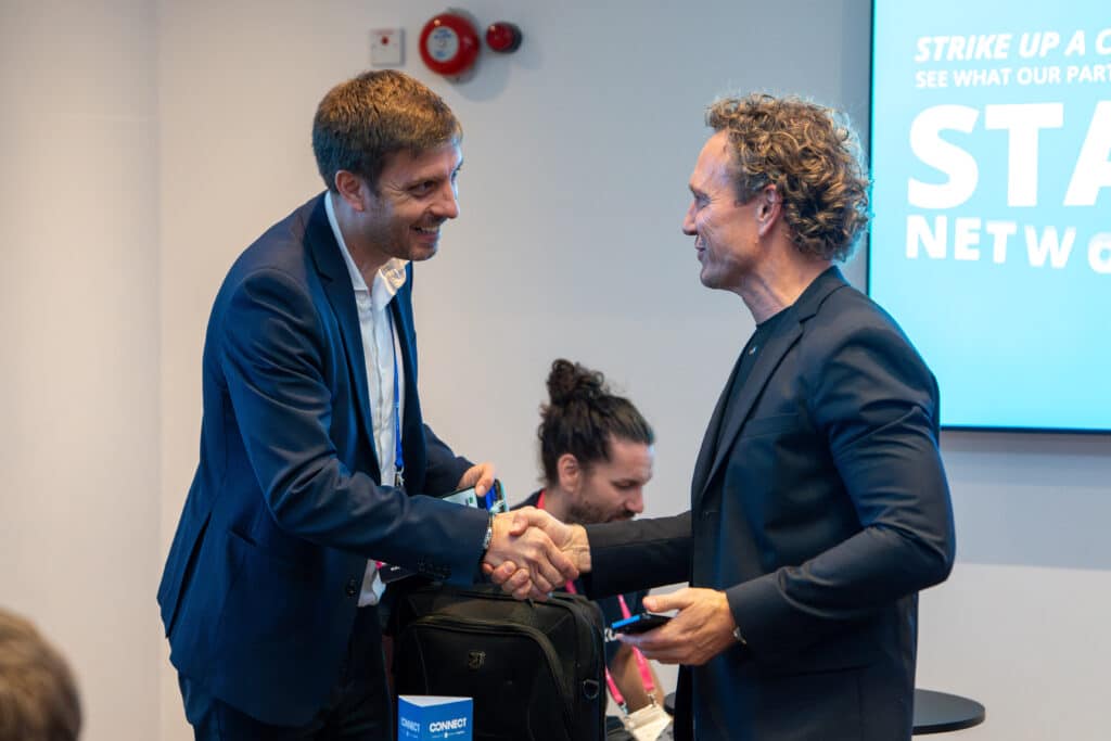 Attendees shaking hands during a networking meeting at Leaders in Logistics Summit